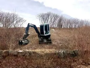 A mini bucked loader performing site work