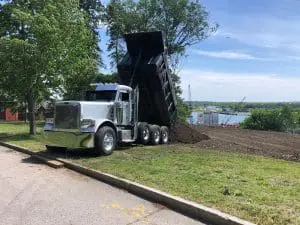 a dump truck bringing in gravel to an earthworks site